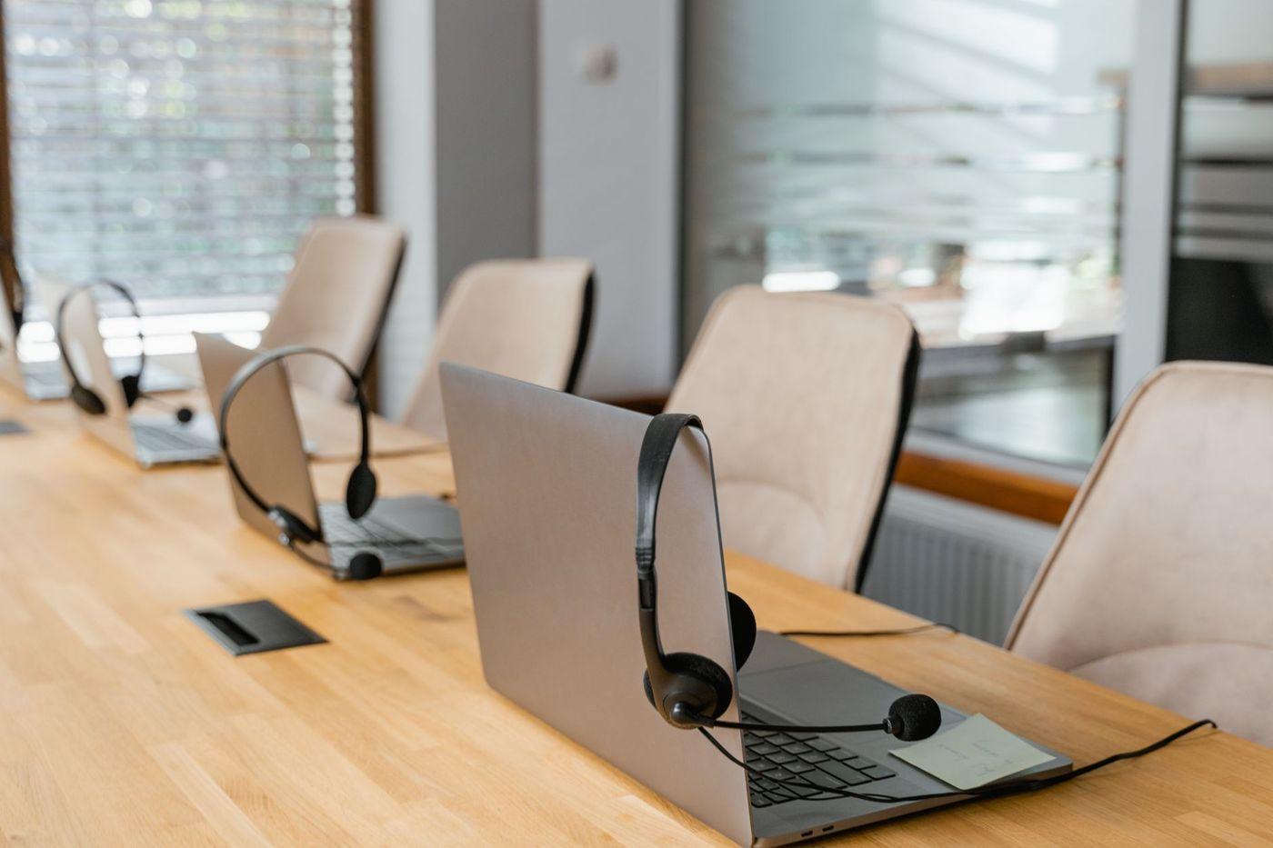 Arbeitsplätze mit Headsets und Laptops in einem hellen Büro