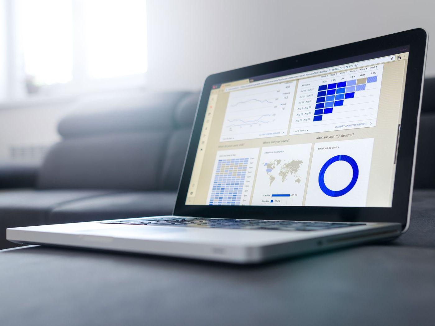 Laptop mit Statistik-Dashboard auf einem Sofa