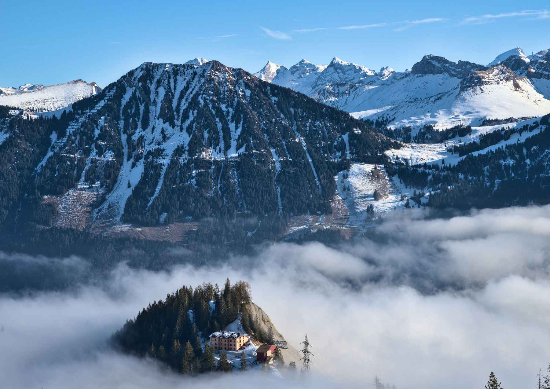 Verschneite Alpen über einem Nebelmeer im Winter